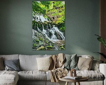 Kleine waterval in het bos met mos op stenen
