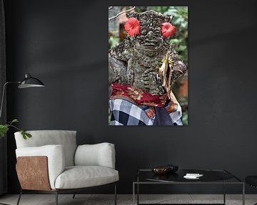 Statue adorned with red flowers in Ubud by Frank Photos