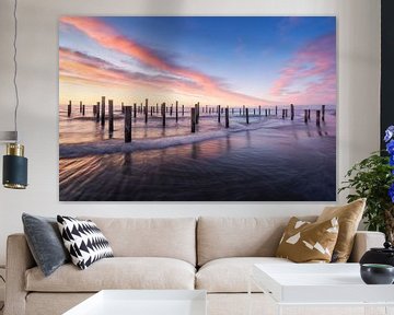 Serene zonsondergang boven houten palen op het strand van Petten, Nederland van Arda Acar