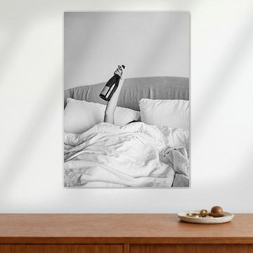 Champagner im Bett - Schwarz-Weiß-Fotografie - Frau mit Alkoholflasche in der Hand Fotografie