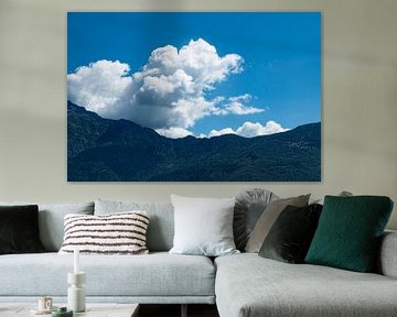 witte wolken boven beboste bergen en blauwe lucht van Rena Miller