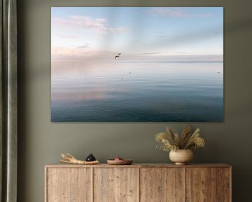 Calm on a pastel-coloured sea with flying seagull by Marit Hilarius