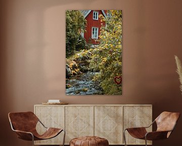 Fruitbomen bij een beekje met een bruggetje voor een rood houten huis in Zweden. van Martin Köbsch