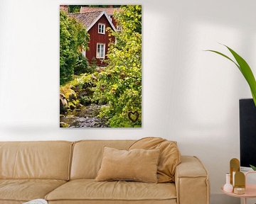 Fruitbomen bij een beekje met een bruggetje voor een rood houten huis in Zweden. van Martin Köbsch