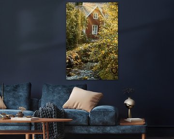 Fruitbomen bij een beekje met een bruggetje voor een rood houten huis in Zweden. van Martin Köbsch