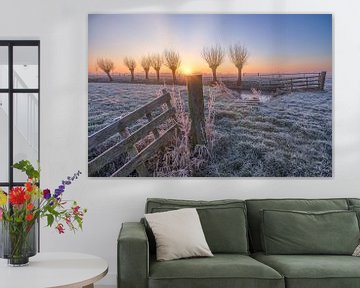 De zon komt op boven een typisch Hollands polderlandschap met een hekje in het weiland en wilgen langs de sloot van Bas Meelker