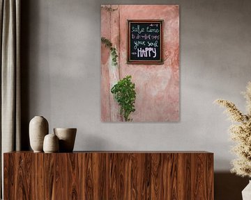 Cheerful text on chalkboard on old pink wall in Mexico by Xulé Bogers