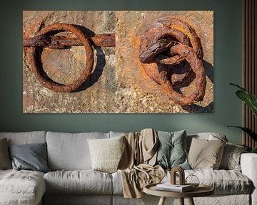 verroeste metalen ringen aan kademuur in Milos, Griekenland