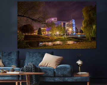 Photographie nocturne colorée du parc de la ville d'Eindhoven avec un bâtiment sur Loes van Dijk
