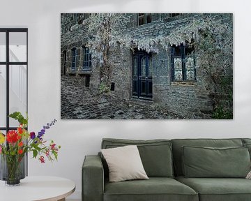 oud huis in dinan met typisch franse blauw geschilderde deuren en wisteria sinensis bloemen op de gevel