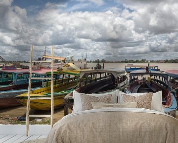 Colourful traditional wooden motorboats in Paramaribo at the river's edge.