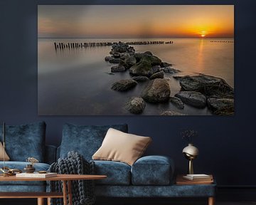 Golfbreker van stenen en palen in het IJsselmeer bij Enkhuizen tijdens mooie zonsopkomst van Bram Lubbers