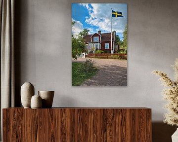 Traditional Swedish red house in Smaland. Red fence and Swedish flag by Martin Köbsch