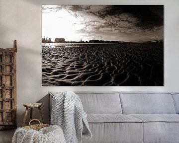 Vast Zandstrand Met Stedelijke Skyline Onder Heldere Blauwe Lucht in Sepia van Youri Mahieu