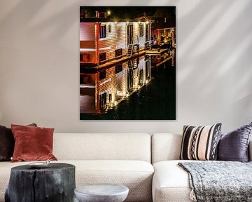 Hausboot mit Beleuchtung und Spiegelung bei Nacht