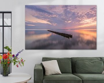 Paaltjes in het IJsselmeer bij Hindeloopen op een mooie zomeravond en zonsondergang van Marga Vroom
