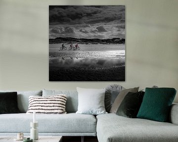 Drei Radfahrer am Strand