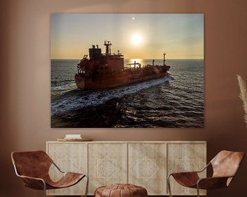 Een eenzame boot drijft stil onder een vurige hemel – een zonsondergang gevangen in vogelvlucht boven het kalme water van een gouden avond van byphotographyms