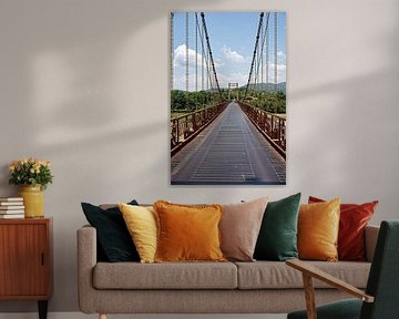Vietnamese suspension bridge in lush natural surroundings by Frank Photos