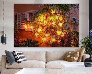 Colourful, bright lanterns on a house wall by Andreas Nägeli