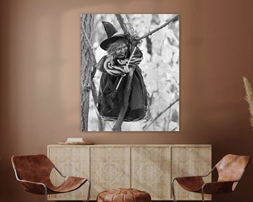 Witch hanging from a branch in black and white.