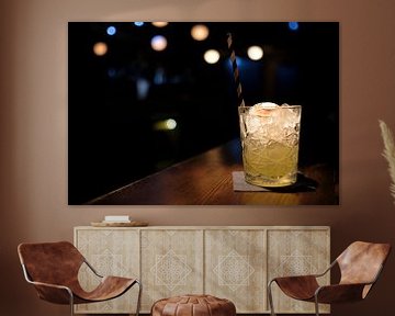 Leckerer Cocktail auf Eis mit Lichtern im Hintergrund von Lensw0rld