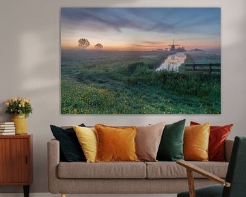 Typische Hollandse lenteochtend met molen De Havik in een decor van een met mist bedekt weiland aan het einde van de dijk