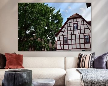 Typisches germanisches / deutsches Fachwerkhaus, Fassade weiß mit Holz, daneben großer alter Baum