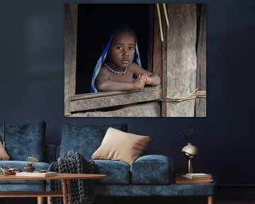 A toddler in a window opening of a Honai by Anges van der Logt