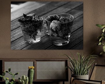 Mooie verse gemengde bloemen geschikt in glazen vazen op houten tafel in zwart-wit