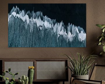 Kunstvolle Wellen auf schwarzem Sand