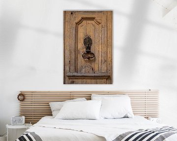 Oude houten deur met decoratieve deurklopper in de Bourgogne (Frankijk)