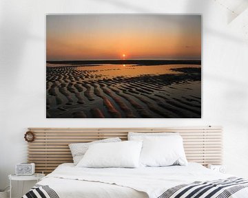 Oranger Sonnenuntergang am Strand mit Sandkämmen