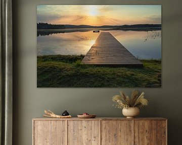 Footbridge, to the sunrise, reaching into a Swedish lake by Martin Köbsch