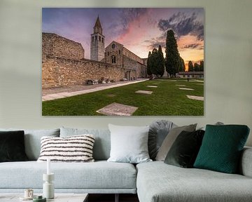 De zon komt op achter de Basiliek van Aquileia en verlicht de aanwezige wolken
