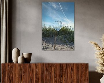 Blauw schepnet met houten paal op een zandstrand met blauwe lucht.