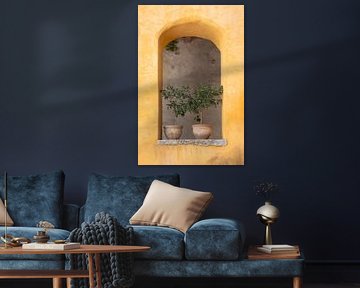 Terracotta potten in okergele muur, mediterrane eenvoud