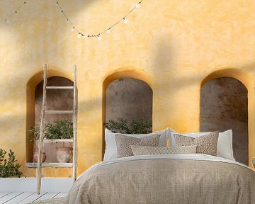 ockerfarbene Wand mit Nischen und Terrakotta-Töpfen - mediterranes Ambiente