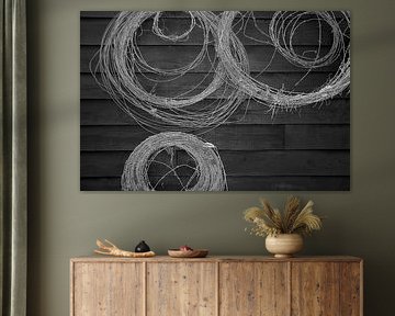 Stacheldraht an einer schwarzen Holzwand