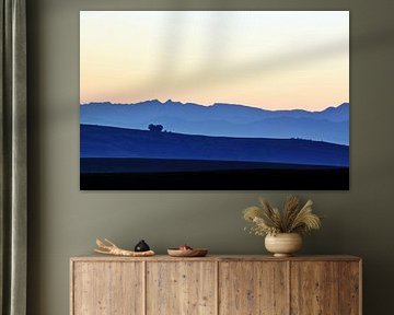 Montagnes et champs au lever du soleil dans la lumière bleue
