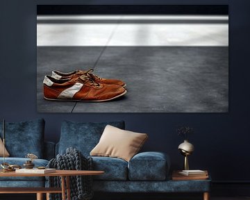 Worn trainers on cold concrete by Frank Heinz