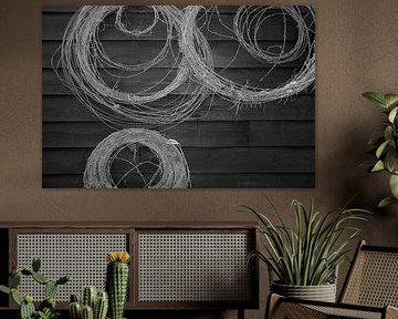Barbed wire on a black wooden wall.