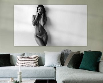 Nu féminin artistique contre un mur blanc