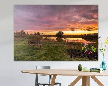 Genieten van de kleurrijke zonsopkomst op een houten bankje bij de Poelboerderij in Wormer van Bram Lubbers