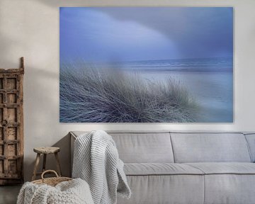 Kustlandschap met duingras op de voorgrond en golven op de achtergrond.