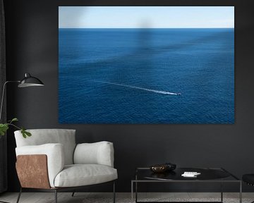 Un bateau glisse sur la mer bleue et calme