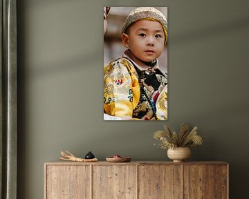 Portrait of a child in traditional ceremonial dress, photographed in Beijing, China,
