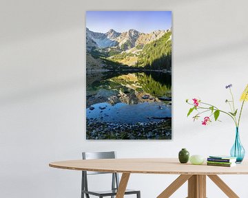 Een idyllisch bergmeer ligt rustig ingebed tussen de ruwe rotswanden van het Karwendelgebergte. Kristalhelder water, omgeven door alpenweiden, lariksbomen en de wilde bergcoulisse.