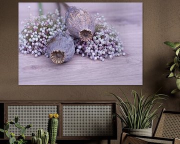 Still life of dried flowers and poppy seed balls on a light wooden background