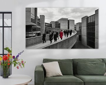 Men in Suits Walking on Concrete Bridge with Red-Coated Man